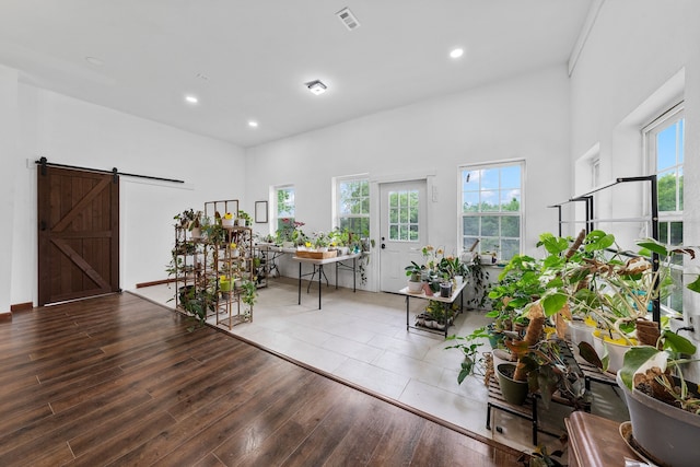 living area featuring wood finished floors, a wealth of natural light, recessed lighting, and a barn door