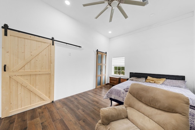 bedroom with a barn door, wood finished floors, a ceiling fan, and recessed lighting