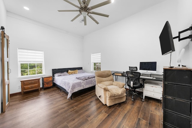bedroom with a barn door, wood finished floors, ceiling fan, visible vents, and recessed lighting
