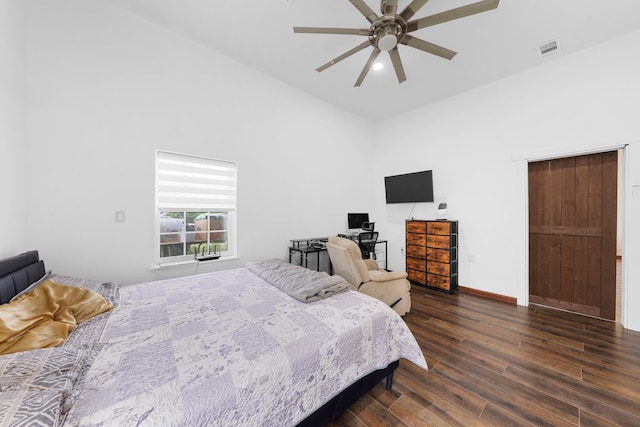 bedroom featuring dark wood finished floors, visible vents, baseboards, high vaulted ceiling, and ceiling fan