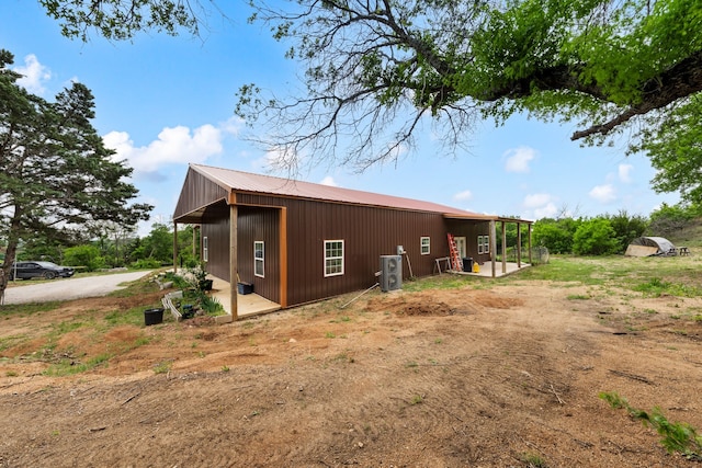 view of property exterior with an outbuilding and metal roof