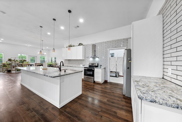 kitchen with dark wood finished floors, wall chimney range hood, a sink, stainless steel range with electric stovetop, and white cabinetry