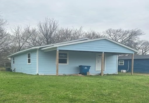 view of side of property with a lawn and central air condition unit
