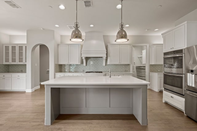 1001 Broadmoor Way, Roanoke, TX 76262 - kitchen featuring visible vents, a sink, decorative backsplash, appliances with stainless steel finishes, and custom range hood