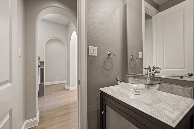 1001 Broadmoor Way, Roanoke, TX 76262 - bathroom with a textured wall, baseboards, wood finished floors, and vanity