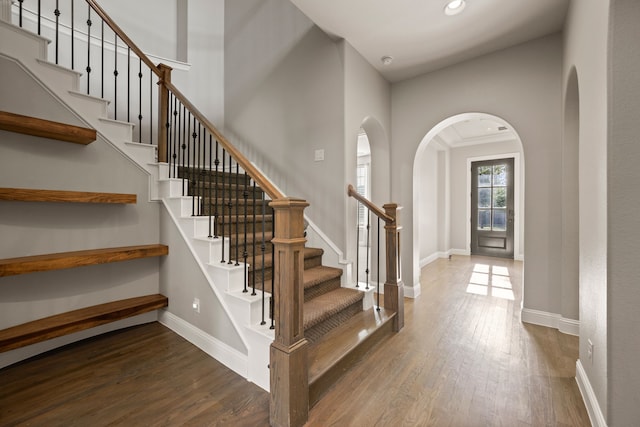 1001 Broadmoor Way, Roanoke, TX 76262 - staircase featuring arched walkways, wood finished floors, baseboards, and recessed lighting