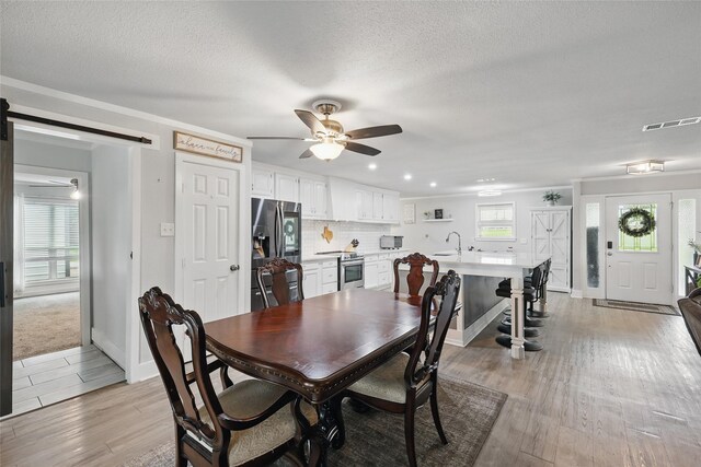 5247 Fm 1569, Farmersville, TX 75442 - carpeted empty room featuring a ceiling fan, a wall mounted AC, a barn door, baseboards, and ornamental molding