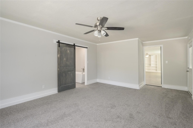 unfurnished room featuring crown molding, ceiling fan, and a barn door