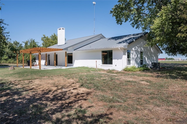 rear view of house featuring a yard, a patio, a chimney, and a pergola