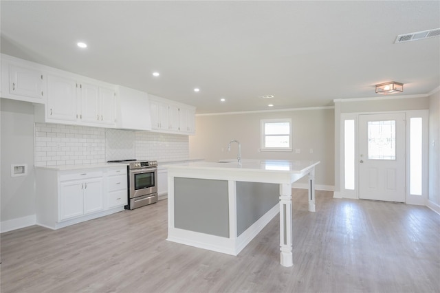 kitchen featuring visible vents, light countertops, white cabinetry, stainless steel electric stove, and ornamental molding