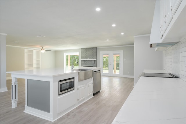 kitchen with appliances with stainless steel finishes, a sink, light countertops, recessed lighting, and ornamental molding