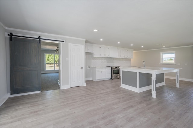 kitchen with a wealth of natural light, ornamental molding, stainless steel electric range, and white cabinets