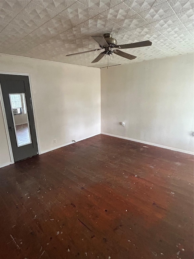 empty room featuring wood-type flooring, ceiling fan, and baseboards