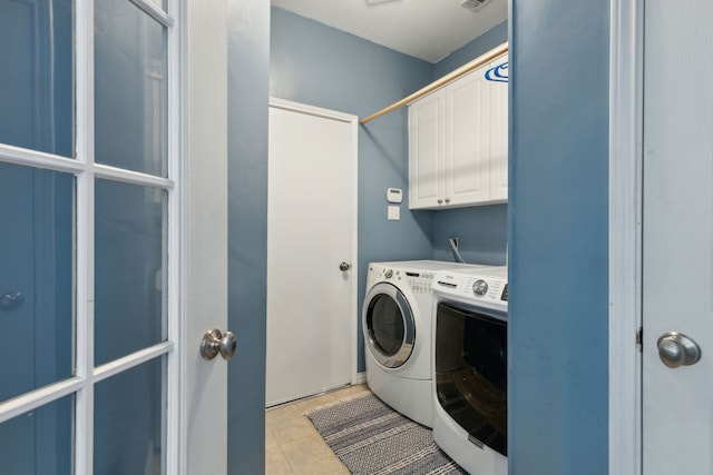 washroom with visible vents, washer and dryer, light tile patterned floors, and cabinet space