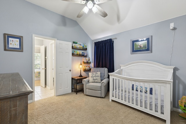 carpeted bedroom featuring vaulted ceiling, a ceiling fan, tile patterned flooring, connected bathroom, and a nursery area