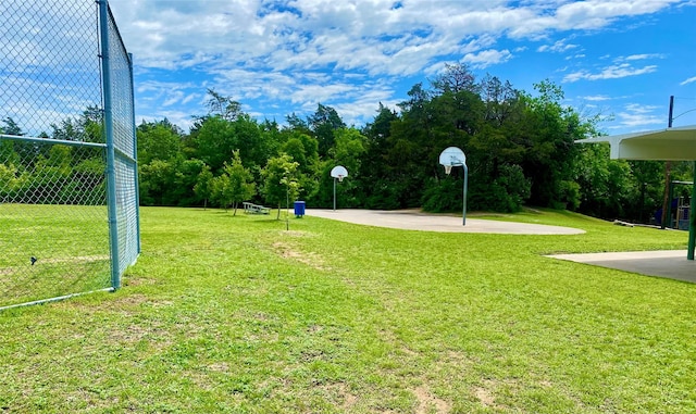 surrounding community with community basketball court and a lawn