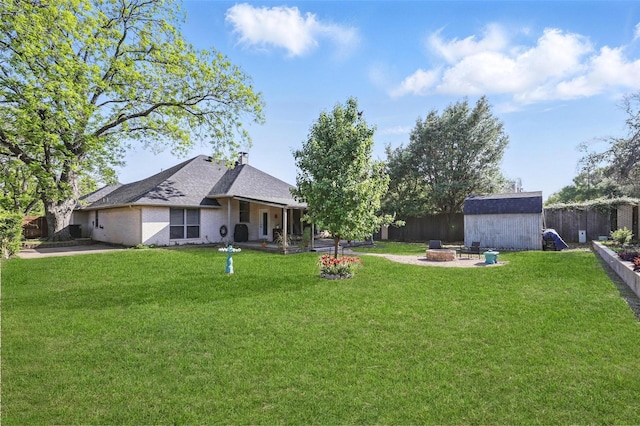1220 Chaparral Ln, Granbury, TX 76048 - view of yard with a fenced backyard, an outbuilding, a shed, and an outdoor fire pit