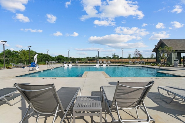 pool with fence and a patio