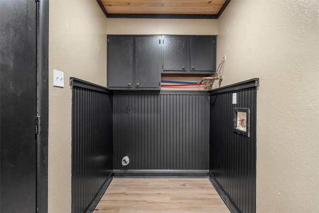 interior space featuring wood ceiling, a textured wall, light wood-style flooring, and laundry area