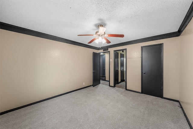 unfurnished bedroom featuring light carpet, crown molding, baseboards, a textured ceiling, and ceiling fan