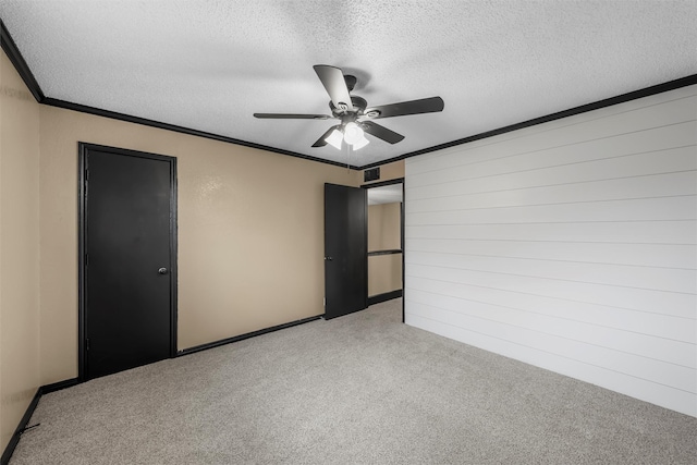 unfurnished bedroom with visible vents, ornamental molding, light carpet, a textured ceiling, and ceiling fan