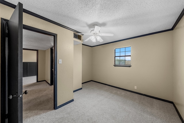 unfurnished bedroom featuring light carpet, baseboards, a textured ceiling, and ornamental molding
