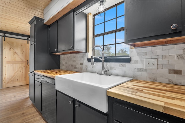 kitchen with wood counters, dark cabinets, a sink, and dishwashing machine