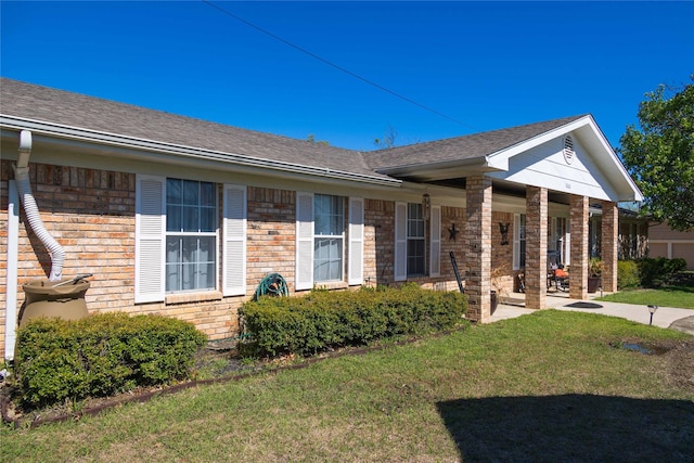 1600 Shaw Dr, Brownwood, TX 76801 - single story home with a porch, a shingled roof, a front lawn, and brick siding