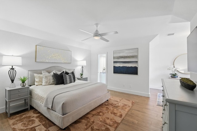 bedroom with a ceiling fan, baseboards, and light wood-style floors