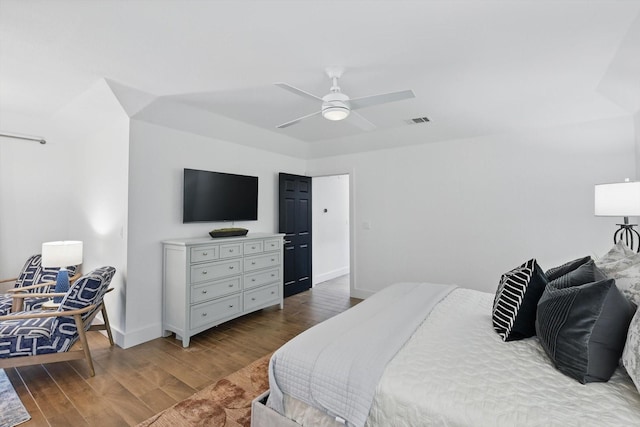 bedroom with baseboards, wood finished floors, visible vents, and a ceiling fan