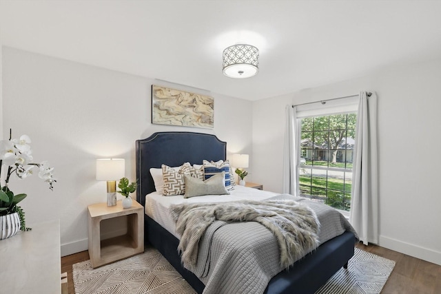bedroom with wood finished floors and baseboards