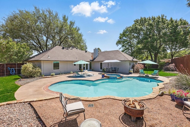 view of swimming pool with a patio area, a fenced backyard, a fire pit, and a pool with connected hot tub