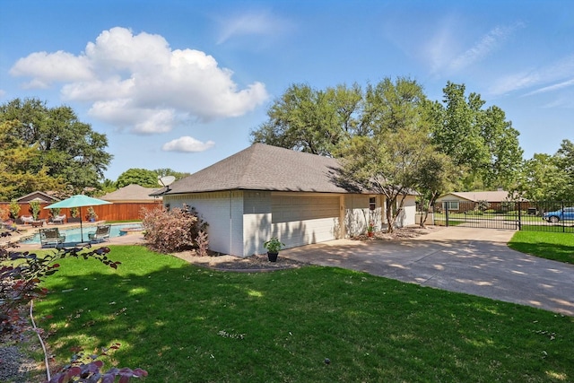 view of home's exterior with a yard, a detached garage, a fenced in pool, and fence