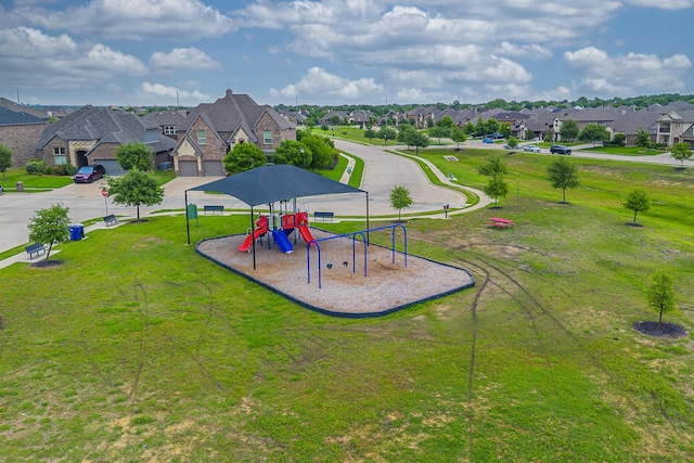 community jungle gym featuring a residential view and a yard