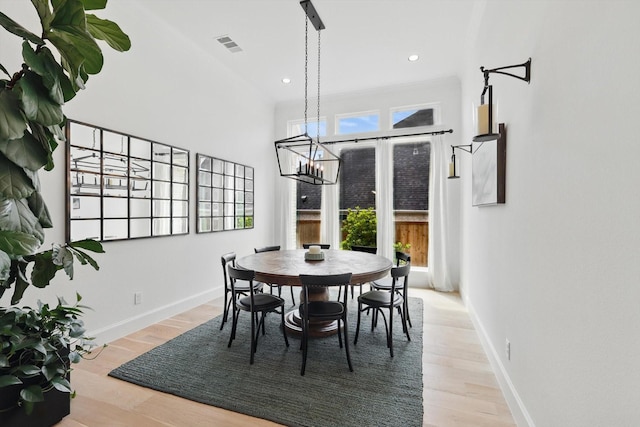 dining area with baseboards, a chandelier, wood finished floors, and visible vents