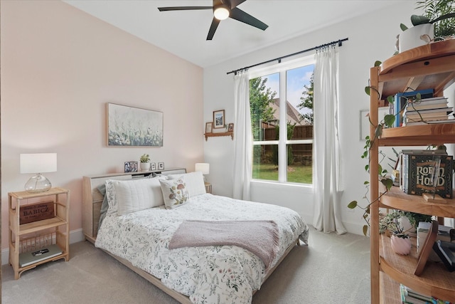 bedroom with baseboards, a ceiling fan, and light carpet