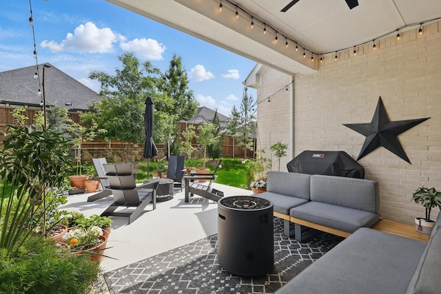 view of patio with a fenced backyard, ceiling fan, an outdoor living space with a fire pit, and a grill