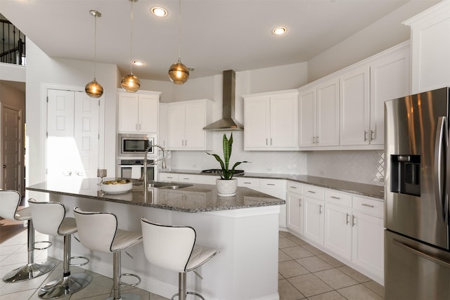 kitchen featuring tasteful backsplash, white cabinets, wall chimney exhaust hood, appliances with stainless steel finishes, and recessed lighting