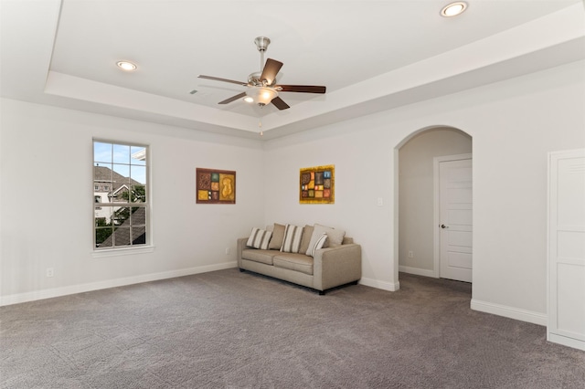sitting room featuring recessed lighting, carpet, a raised ceiling, arched walkways, and ceiling fan