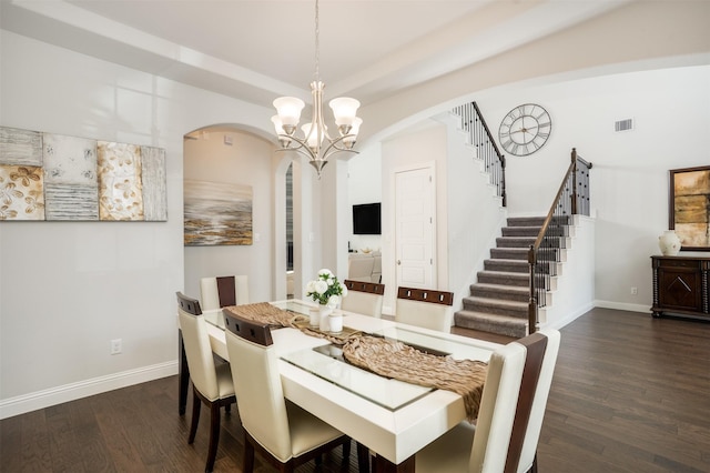 dining space with arched walkways, an inviting chandelier, dark wood-style floors, and baseboards
