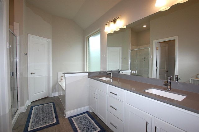 bathroom featuring a bath, a sink, a shower stall, and double vanity