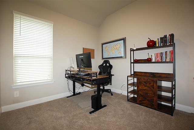 carpeted office space featuring vaulted ceiling and baseboards