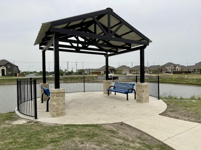 view of property's community featuring fence, a water view, and a residential view