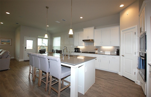 kitchen with recessed lighting, stainless steel appliances, backsplash, a sink, and dark wood-style floors