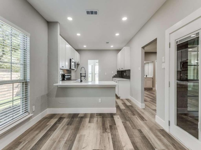 kitchen with white cabinets, light wood-style flooring, visible vents, and appliances with stainless steel finishes