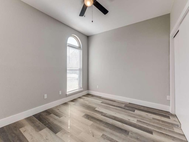 unfurnished room featuring baseboards, a ceiling fan, and wood finished floors