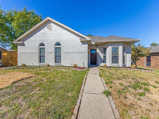single story home with brick siding and a front lawn