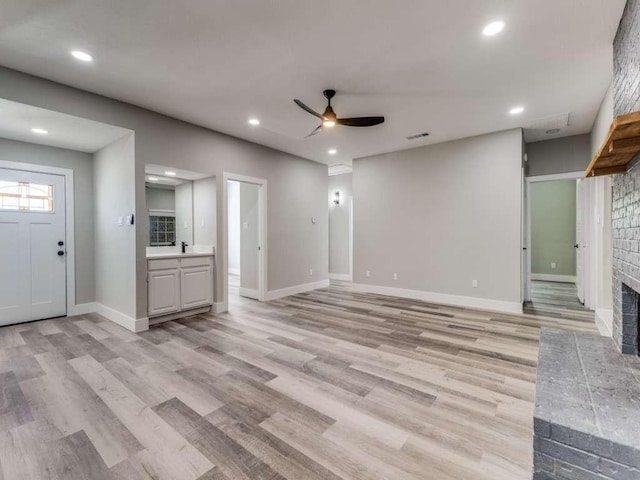 1001 Primrose St, Mesquite, TX 75149 - unfurnished living room featuring a ceiling fan, light wood-style floors, a brick fireplace, recessed lighting, and baseboards