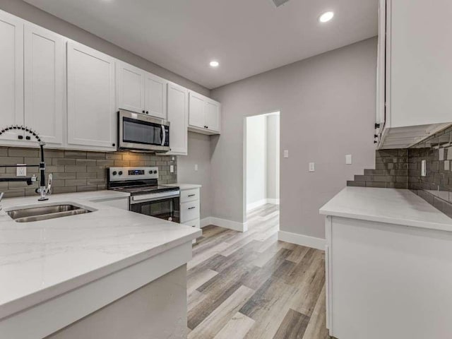 1001 Primrose St, Mesquite, TX 75149 - kitchen with stainless steel appliances, a sink, white cabinets, baseboards, and decorative backsplash