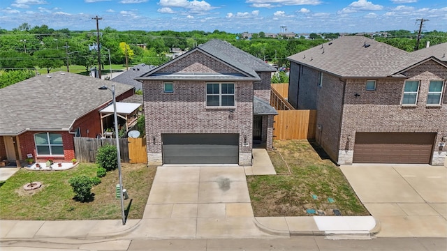 view of front facade with fence, concrete driveway, an attached garage, and brick siding